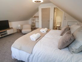 A bedroom with a bed towels and television at Cosy Retreat