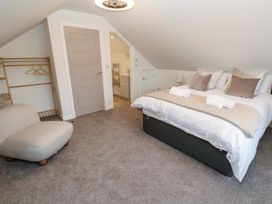 A bedroom with a bed and a chair at Cosy Retreat