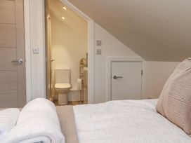 A bedroom featuring a bed and an adjoining bathroom at Cosy Retreat 