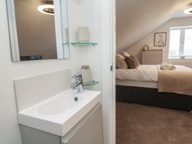 A bathroom sink and mirror with a bed in the background at Cosy Retreat