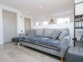 A living room with a sofa and bookshelves at Cosy Retreat in Pool