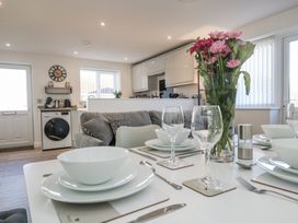 A dining area with a table and kitchen view at Cosy Retreat in Pool