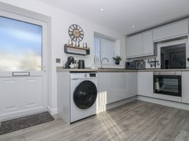 A kitchen with a washing machine and microwave at Cosy Retreat in Pool