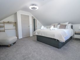 A bedroom with a bed and sitting chair at Cosy Retreat in Pool