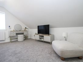 A living room with a tv and storage unit at Cosy Retreat in Pool
