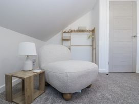A chair next to a lamp and table at Cosy Retreat in Pool