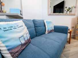 A living room with a sofa and cushions at Sea Whispers in Marazion
