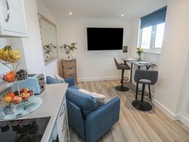 A kitchen with a sofa and dining table at Sea Whispers in Marazion