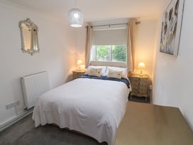 A bedroom with a bed and nightstand at Sea Whispers in Marazion