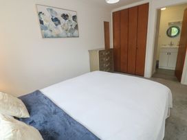A bedroom with a bed and dresser at Sea Whispers in Marazion