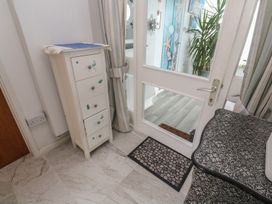A hallway with a chest of drawers and door at Sea Whispers in Marazion