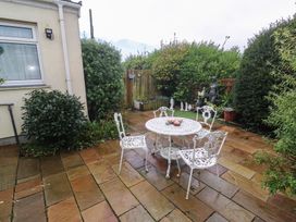 A garden with a table and chairs at Sea Whispers in Marazion