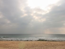 A beach with waves and clouds at Sea Whispers in Marazion