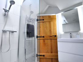 A bathroom with shower, towel radiator, mirror and wooden door at proposed 3 bed apartment Lyme Regis