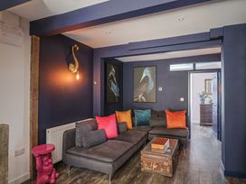A living room with a sofa and wall art at Avocet in Lyme Regis