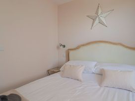 A bedroom with a bed and decorative items at Avocet in Lyme Regis