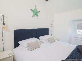 A bedroom with a bed and bedside table at Avocet in Lyme Regis