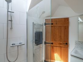 A bathroom with a shower and sliding door at Avocet in Lyme Regis