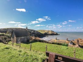 A church and coastline view at 3 Brooks Cottages Hope Cove