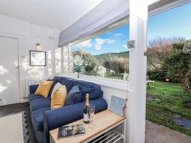 A snug with a couch and table at 3 Brook Cottages in Hope Cove