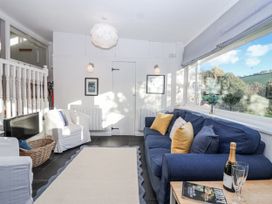 A living room with a sofa and television at 3 Brook Cottages Hope Cove