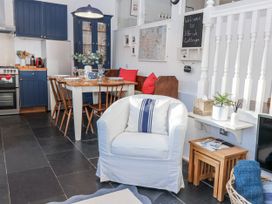 A living room with a dining table and sofa at 3 Brook Cottages Hope Cove