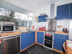 A kitchen with a microwave and sink at 3 Brook Cottages in Hope Cove