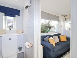 A snug with a sofa and window at 3 Brook Cottages in Hope Cove