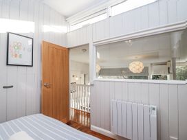 A bedroom with a door and a window at 3 Brook Cottages in Hope Cove