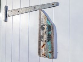 A wooden piece with a metal hinge attached on a white wall at 3 Brook Cottages in Hope Cove