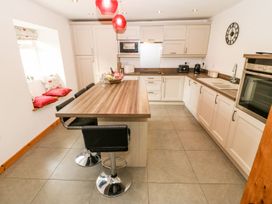 A kitchen with a table and chairs at The Old Barn in Pwllheli
