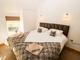 A bedroom with a bed and window at The Old Barn in Pwllheli