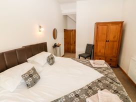 A bedroom with a large bed and wooden furniture at the property Pwllheli