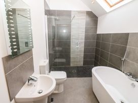 A bathroom with shower and bathtub at The Old Barn in Pwllheli