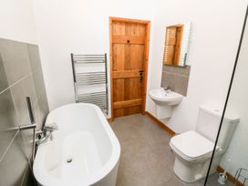 A bathroom with a bathtub and toilet at The Old Barn in Pwllheli