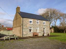 A house with windows and a bench in front at Pwllheli