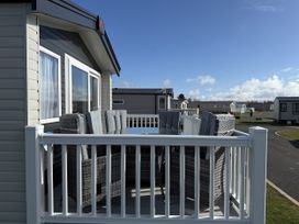 A deck with a table and chairs at 30 Wells Close, Berwick-upon-Tweed