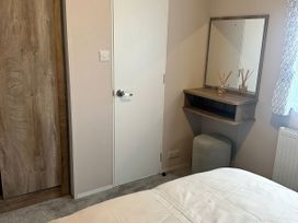 A bedroom with a dressing table and mirror at 30 Wells Close, Berwick-upon-Tweed