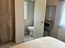 A bathroom with a toilet and mirror at 30 Wells Close in Berwick-upon-Tweed
