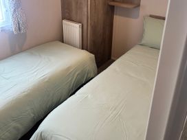 A bedroom with two single beds and a radiator at 30 Wells Close in Berwick-upon-Tweed