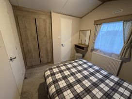 A bedroom with a bed and wardrobe at 30 Wells Close in Haggerston