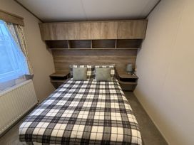 A bedroom with a bed and shelves at 30 Wells Close Haggerston