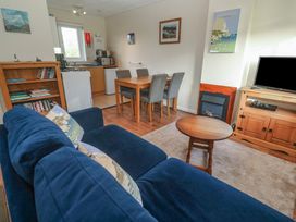 A living room with a sofa and dining area at Little Egret - Number 2