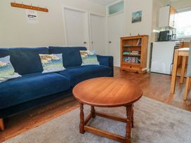 A living room with a blue sofa and wooden coffee table at Little Egret - Number 2 