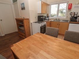 A kitchen with wooden table and chairs at Little Egret - Number 2