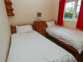 A bedroom with two single beds and a nightstand at Little Egret - Number 2