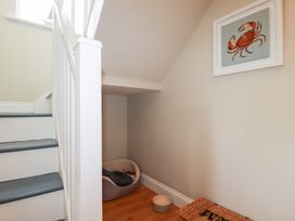 A stairway with a dog bed and a pet bowl at The Mizzen St Endellion near Port Isaac