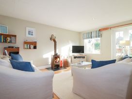 A living room with a stove and television at The Mizzen in St Endellion near Port Isaac