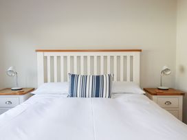 A bedroom with a bed and bedside lamps at The Mizzen St Endellion near Port Isaac