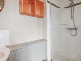 A bathroom with a sink, toilet, and shower at The Mizzen in St Endellion near Port Isaac